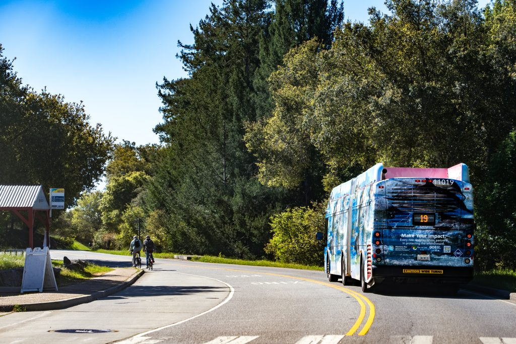 Number 19 bus driving by people on bikes