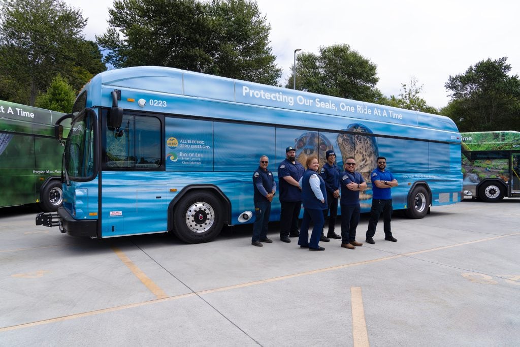 Metro employees standing in front of bus