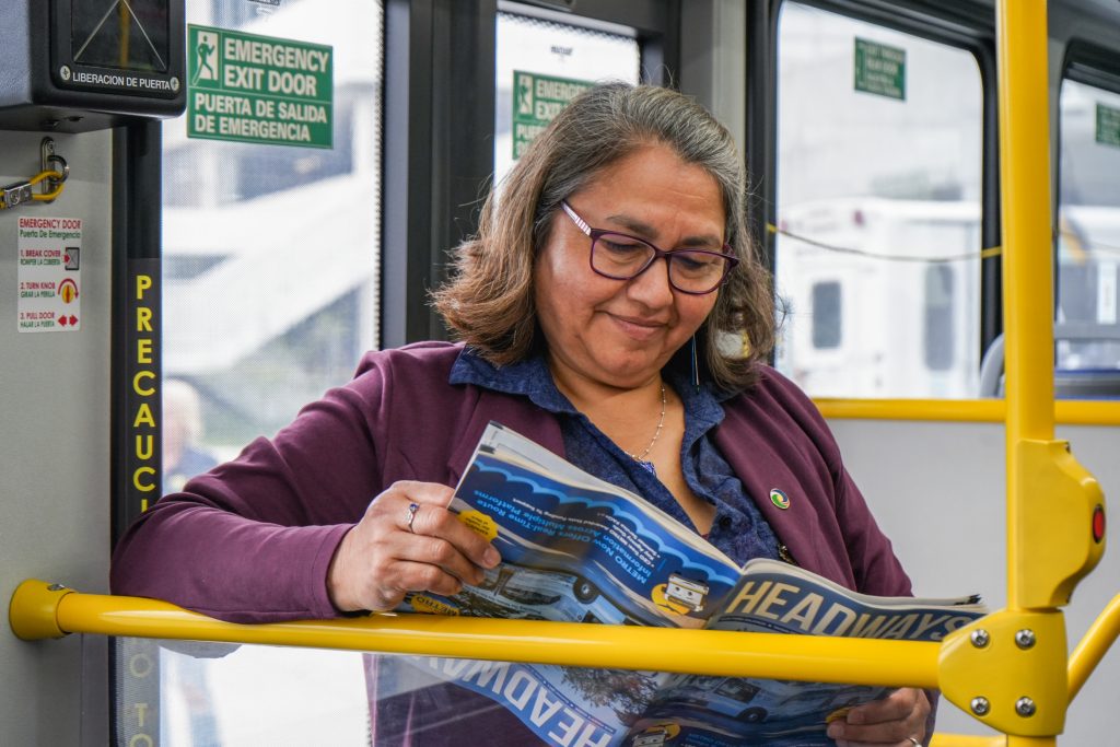 Woman reading Headways standing in bus