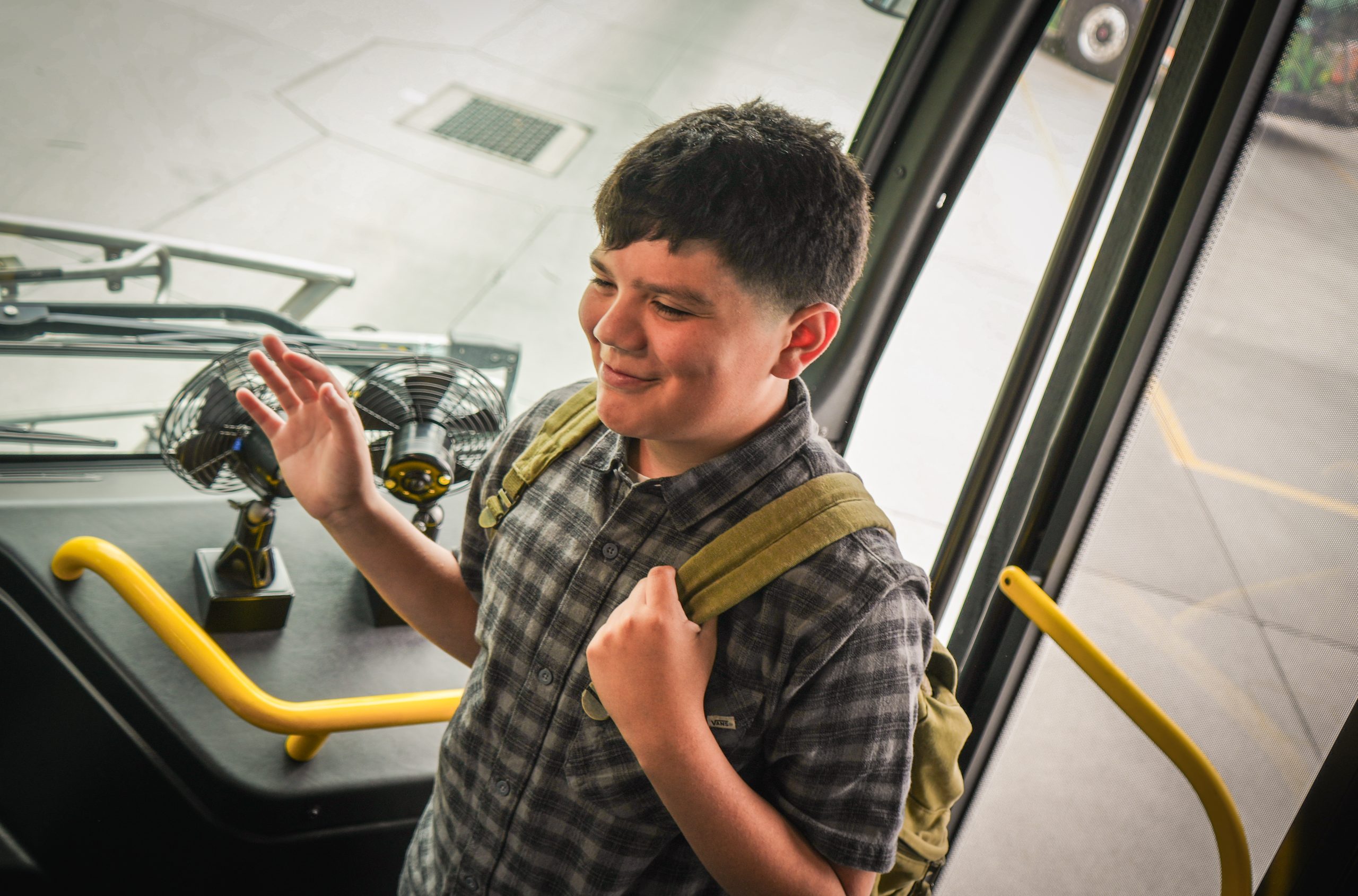 Boy entering bus smiling