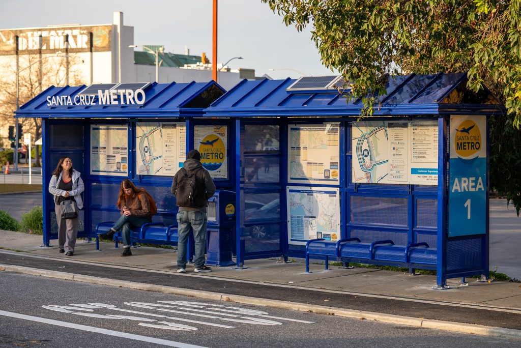 People standing and sitting at SC Metro bus shelter