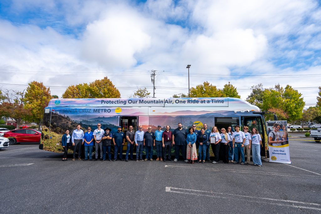 SC Metro employees standing in front of One Ride at a Time bus in parking lot.